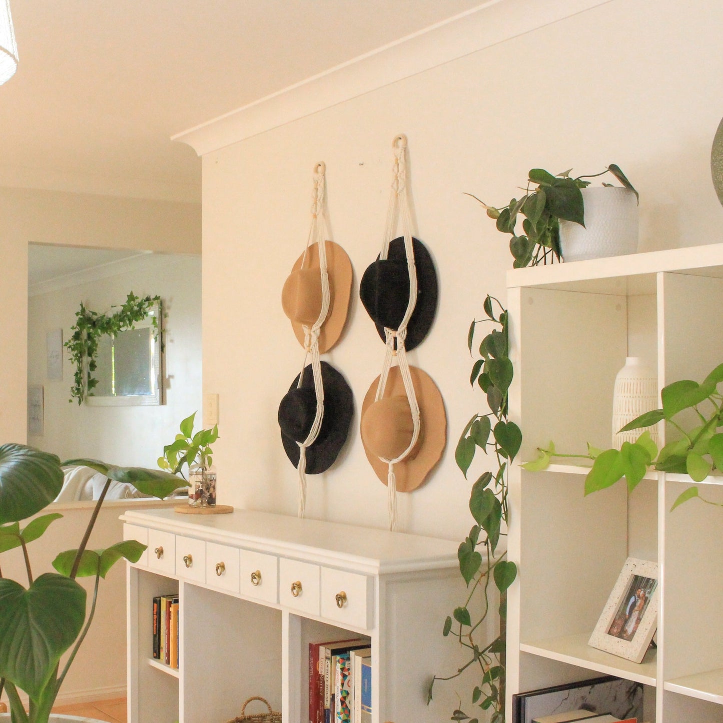 Macrame Hat Hangers in a living dining room with green plants wooden and white furnishings and books