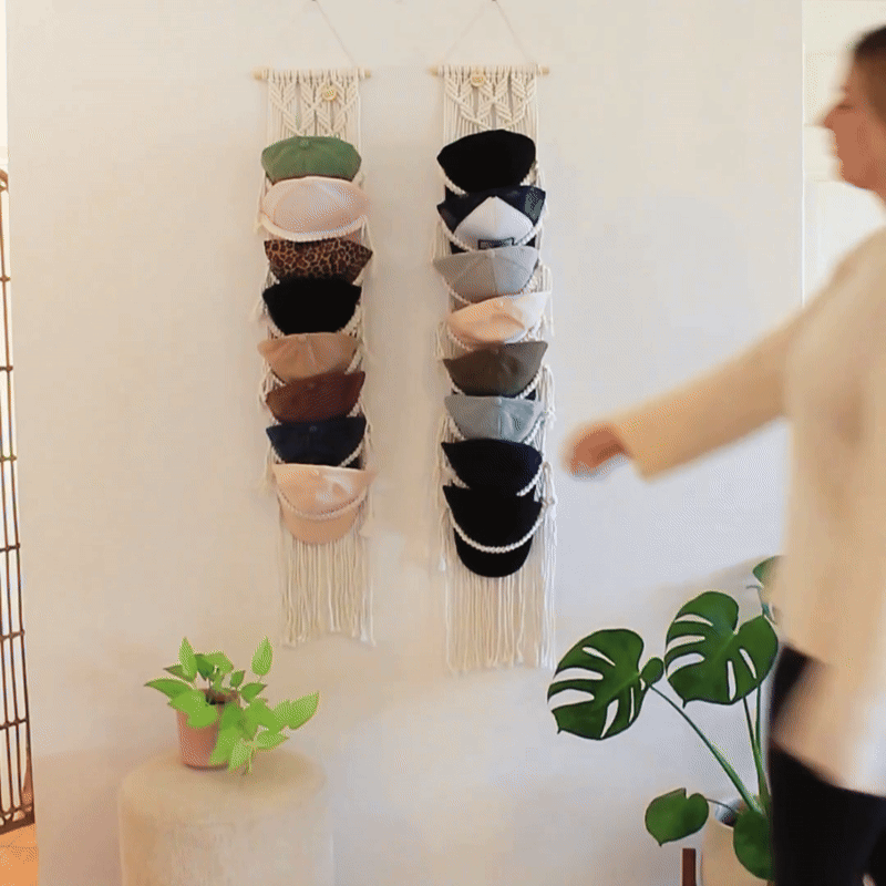 Macrame Cap Hanger displayed on wall while woman trying it on by Sage and Twine