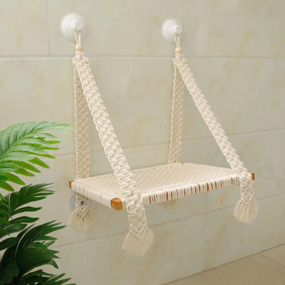 Macrame cat hammock in a cream beige cotton, secured to a white tile wall