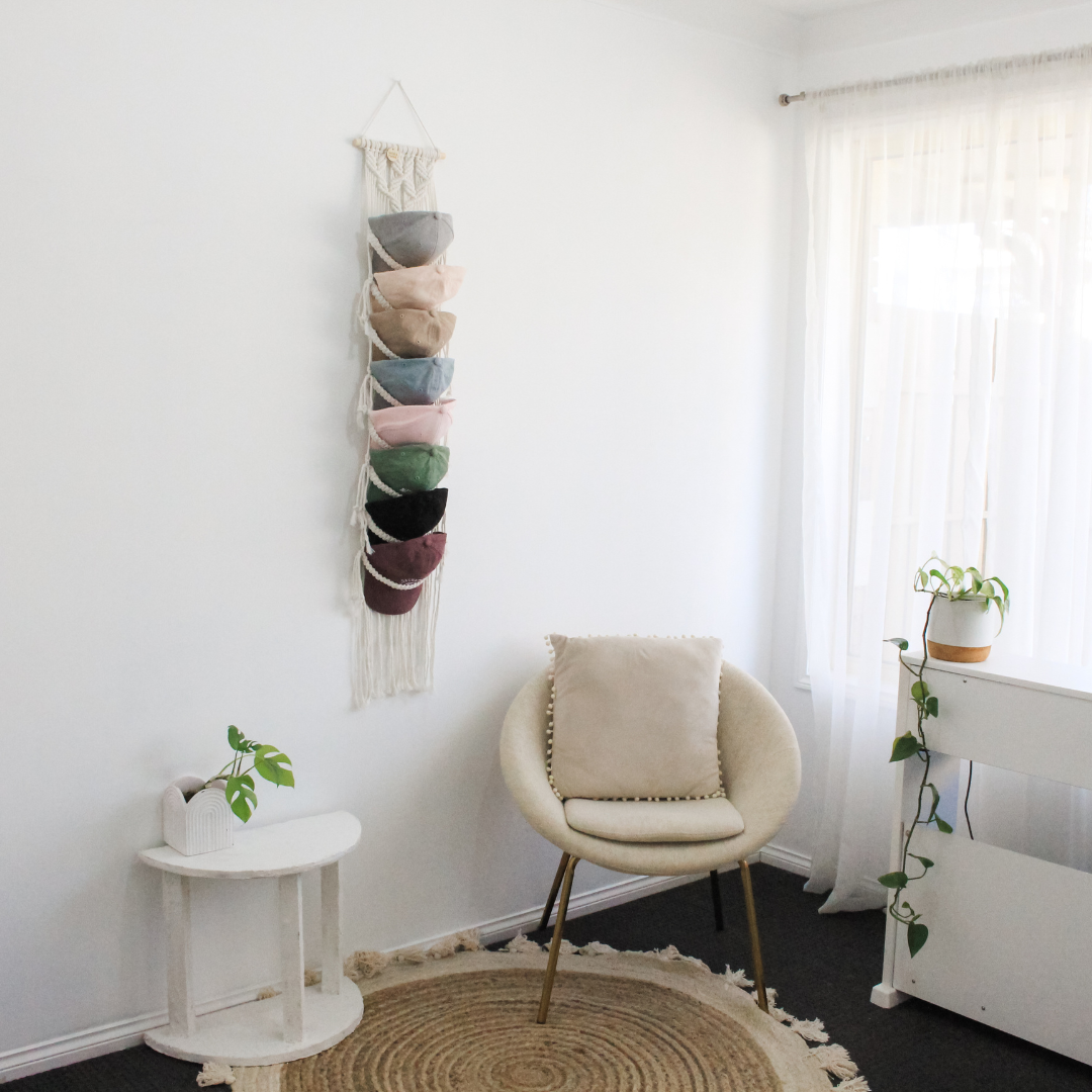 Macrame Cap Hanger in a bright white room decorated with plants and boho accents