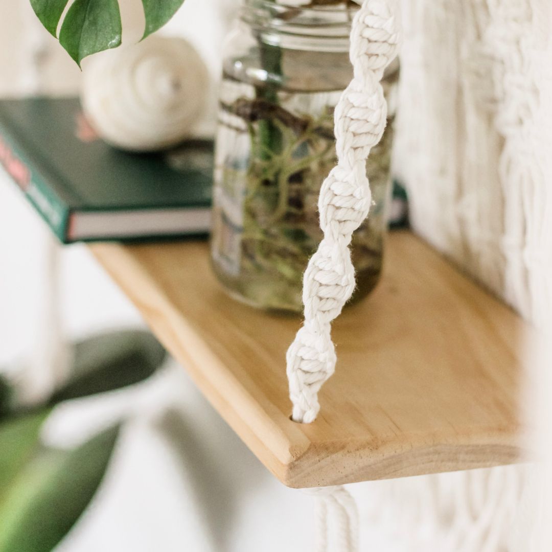 a close up of the macrame shelfs intricate woven cotton showing the dna pattern spiral. this macrame shelf is hand made by sage and twine